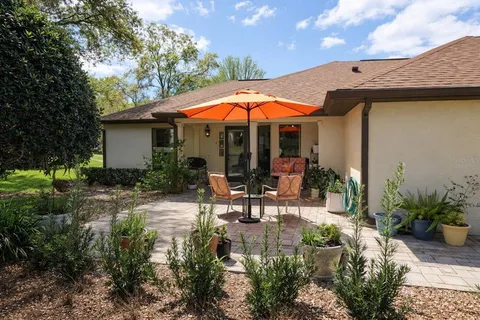 a view of a patio with table and chairs under an umbrella