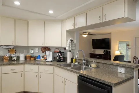 a kitchen with sink a microwave and cabinets