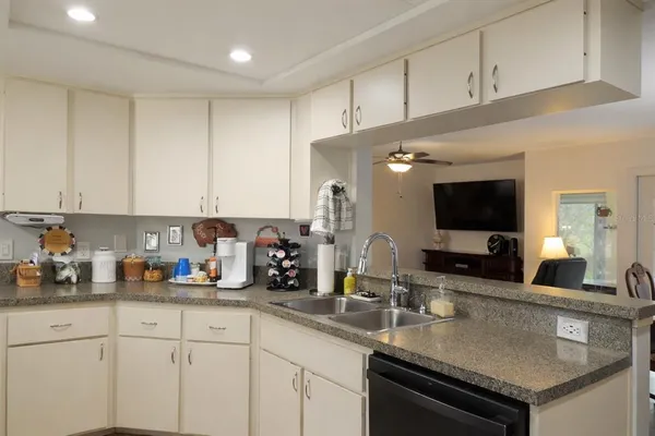 a kitchen with sink a microwave and cabinets