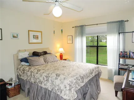 a bedroom with a bed and a large window