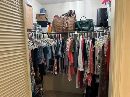 a view of walk in closet with clothes