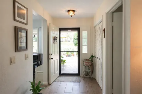 a view of a hallway with wooden floor and a livingroom