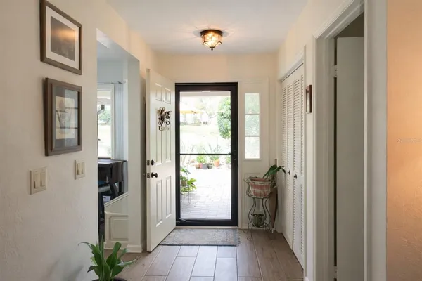 a view of a hallway with wooden floor and a livingroom