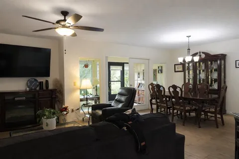 a living room with furniture a flat screen tv and kitchen view