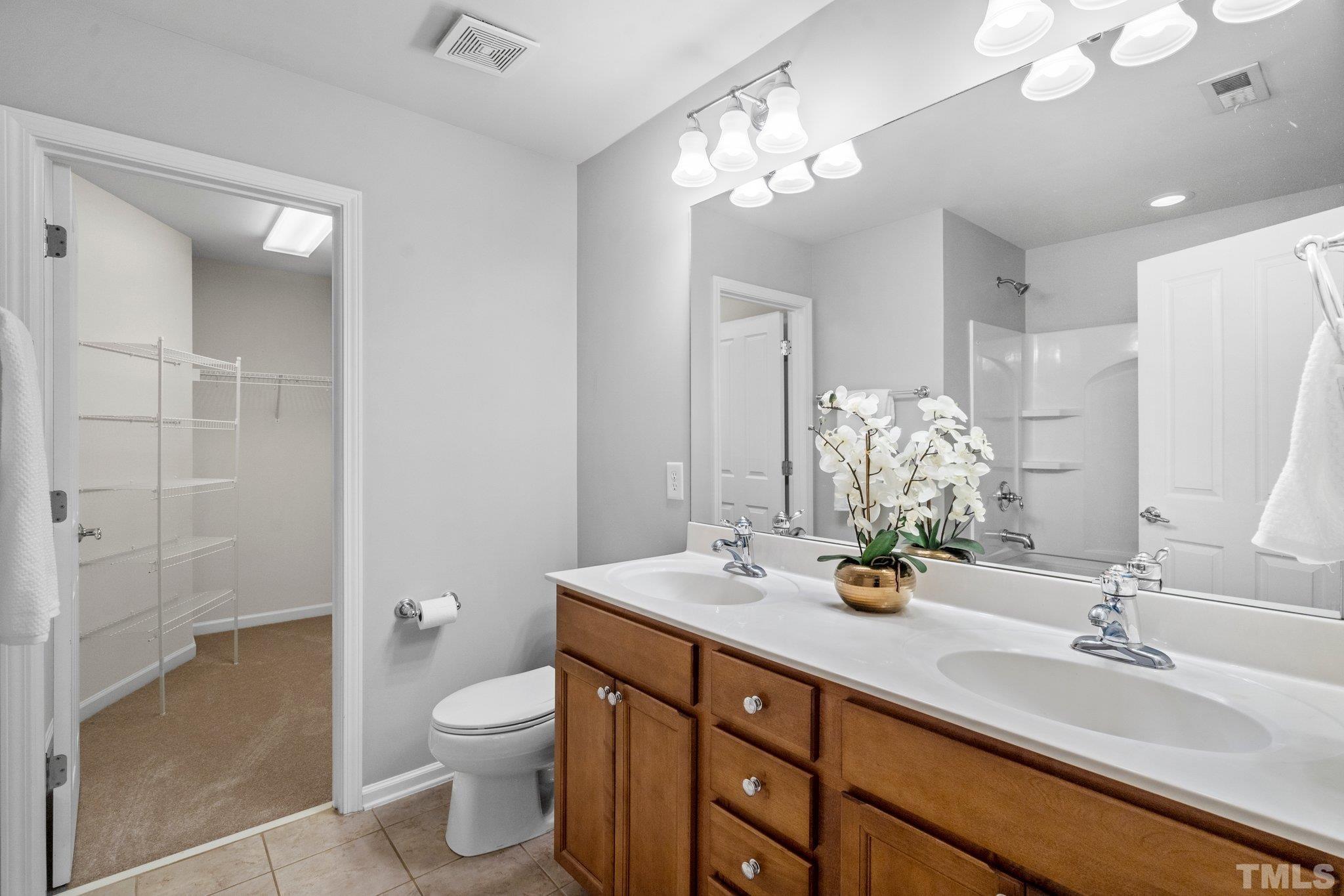 8308 Pilots View Drive Raleigh, NC 27617 - Photo 18 of 29 a bathroom with a double vanity sink mirror and toilet
