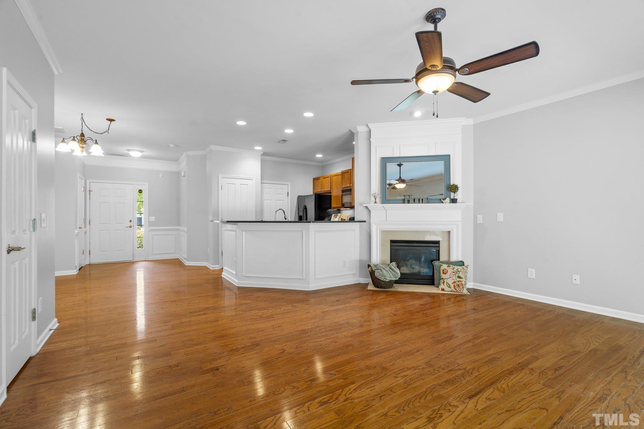 8308 Pilots View Drive Raleigh, NC 27617 - Photo 4 of 29 a view of a livingroom with a fireplace a ceiling fan and kitchen view