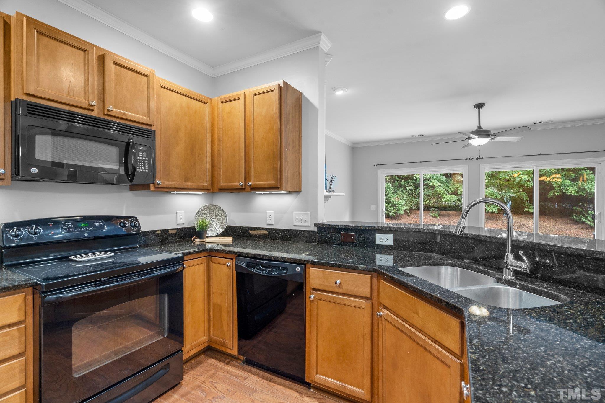 8308 Pilots View Drive Raleigh, NC 27617 - Photo 7 of 29 a kitchen with granite countertop a sink stainless steel appliances and cabinets