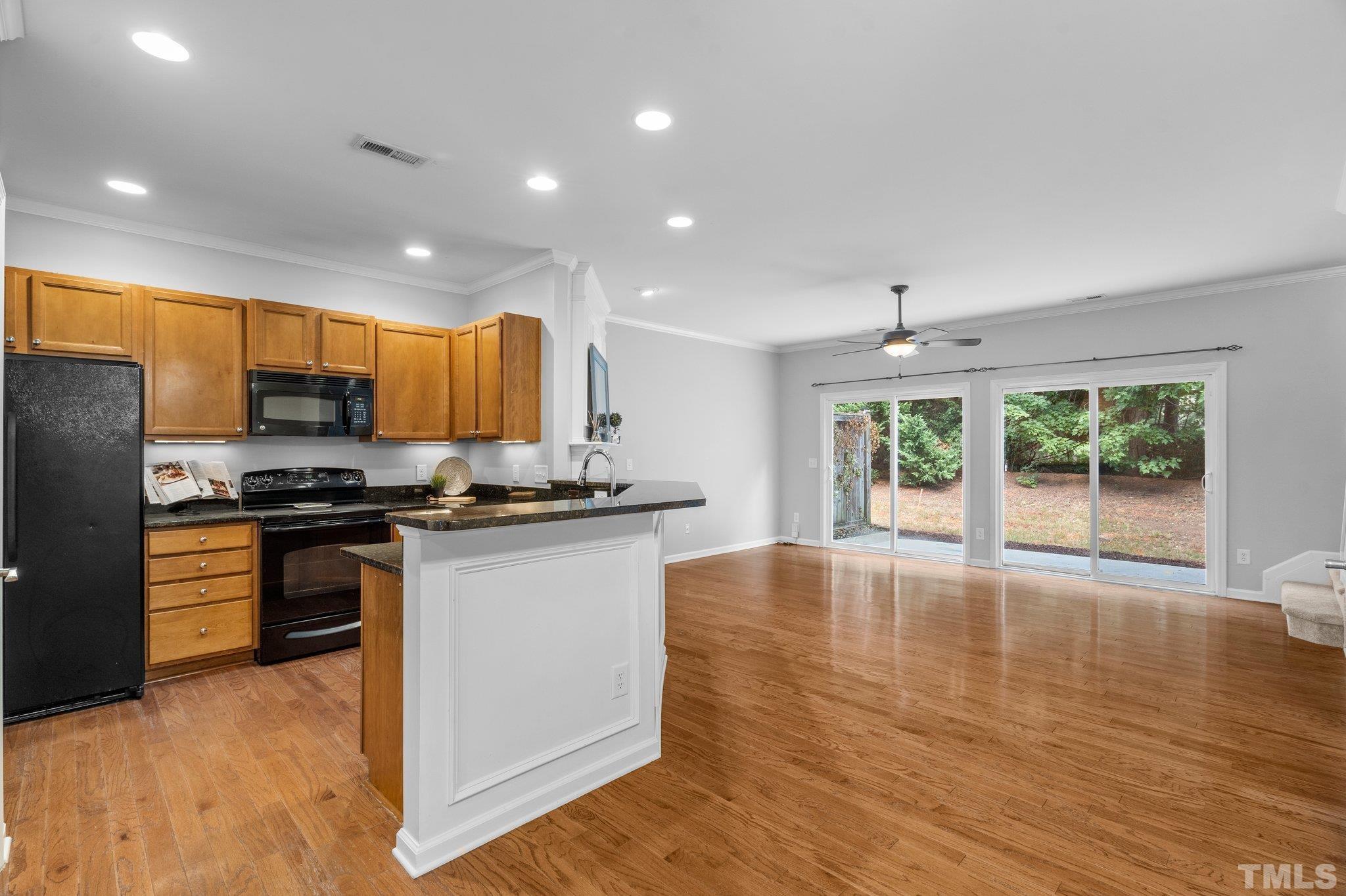 8308 Pilots View Drive Raleigh, NC 27617 - Photo 9 of 29 a kitchen with stainless steel appliances granite countertop wooden cabinets a stove a sink and a large window