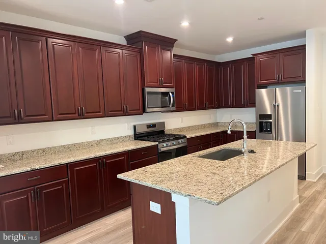 a kitchen with granite countertop stainless steel appliances and wooden cabinets