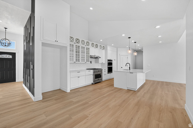 572 West 500th Street North Mapleton, UT 84664 - Photo 12 of 46 Kitchen with hanging light fixtures, white cabinetry, glass fronted cabinets, stainless steel appliances, and a kitchen island with sink