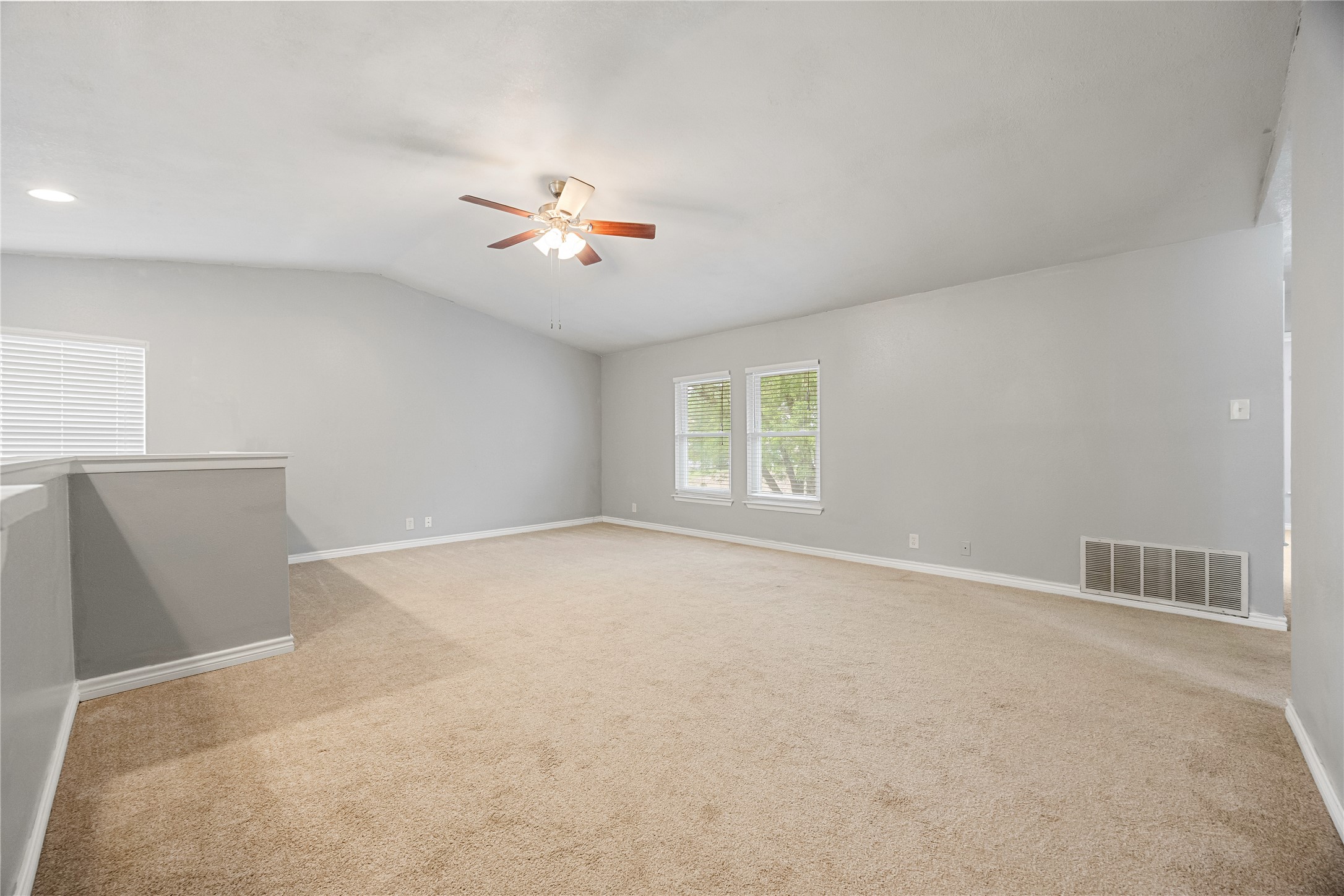 9735 Fortune Ridge Drive Converse, TX 78109 - Photo 28 of 38 Spacious room featuring vaulted ceilings, a ceiling fan, and carpeted flooring