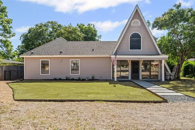 a view of a yard in front of a house with large tree