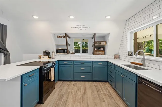 a kitchen with stainless steel appliances granite countertop a sink stove and cabinets