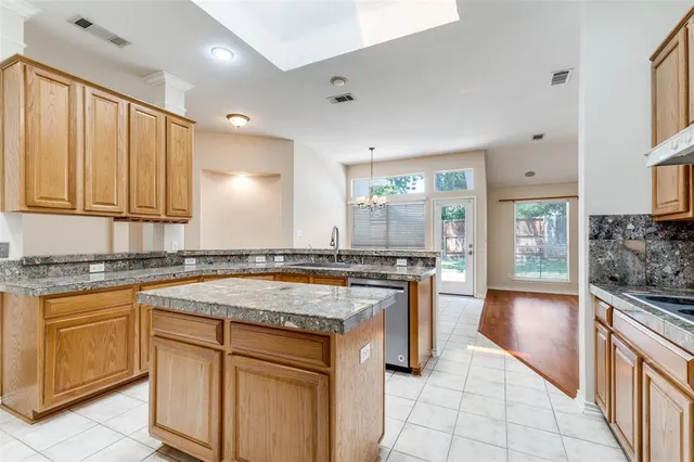 a kitchen with stainless steel appliances granite countertop a stove a sink and a refrigerator