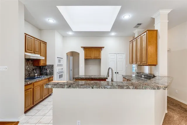 a kitchen with stainless steel appliances granite countertop a sink stove and cabinets