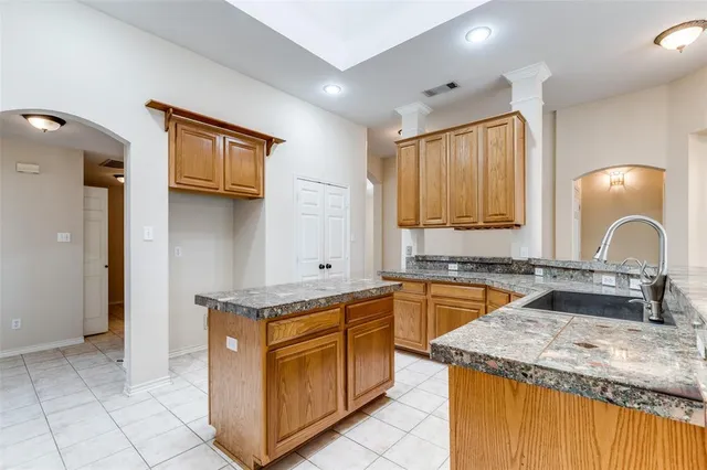 a kitchen with granite countertop a sink stove and cabinets