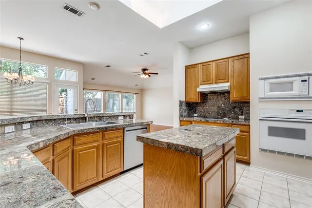 a kitchen with a stove sink and cabinets