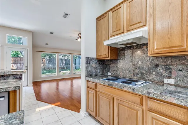 a kitchen with granite countertop a stove a sink and cabinets