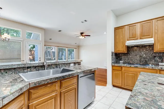 a kitchen with granite countertop a sink stove and cabinets