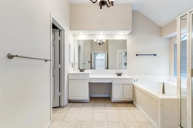 a large white bathroom with a sink a mirror and a bathtub