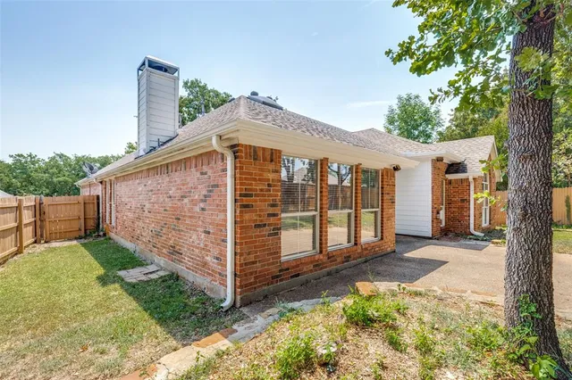 a view of a small house with wooden fence