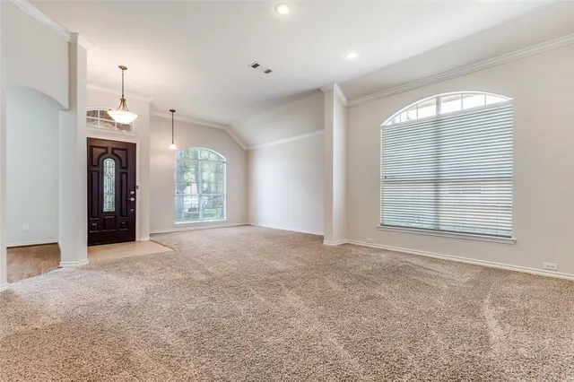 an empty room with windows and fireplace
