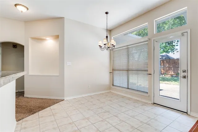 a view of a livingroom with a chandelier fan and windows