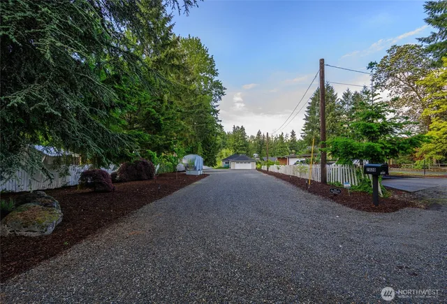 a view of a street with a yard and trees