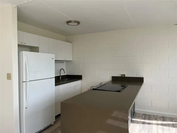 a kitchen with cabinets and refrigerator