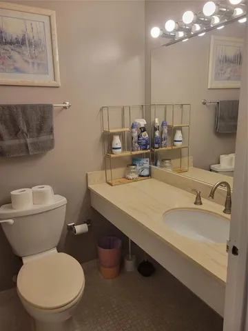 a bathroom with a toilet sink and mirror