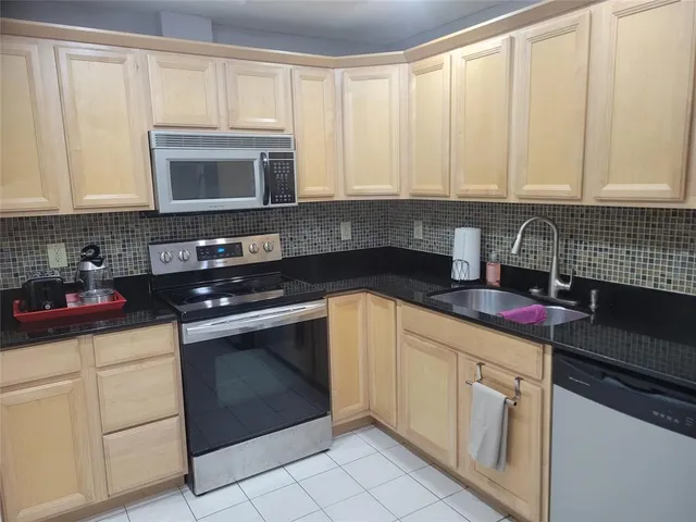 a kitchen with white cabinets and black appliances