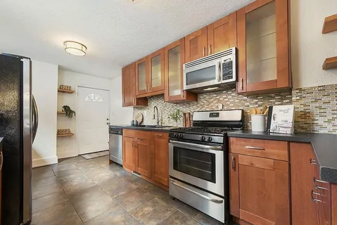 a kitchen with stainless steel appliances granite countertop a stove microwave and refrigerator