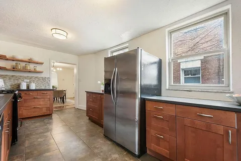 a kitchen with stainless steel appliances granite countertop a refrigerator and a stove
