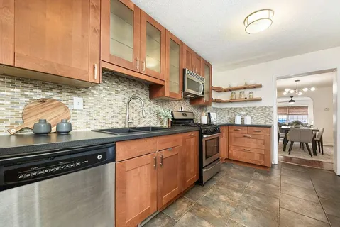 a kitchen with stainless steel appliances granite countertop a sink and cabinets