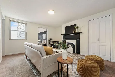 a living room with furniture a fireplace and a flat screen tv