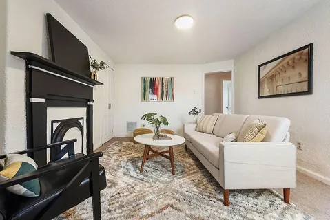 a living room with furniture a flat screen tv and a fireplace