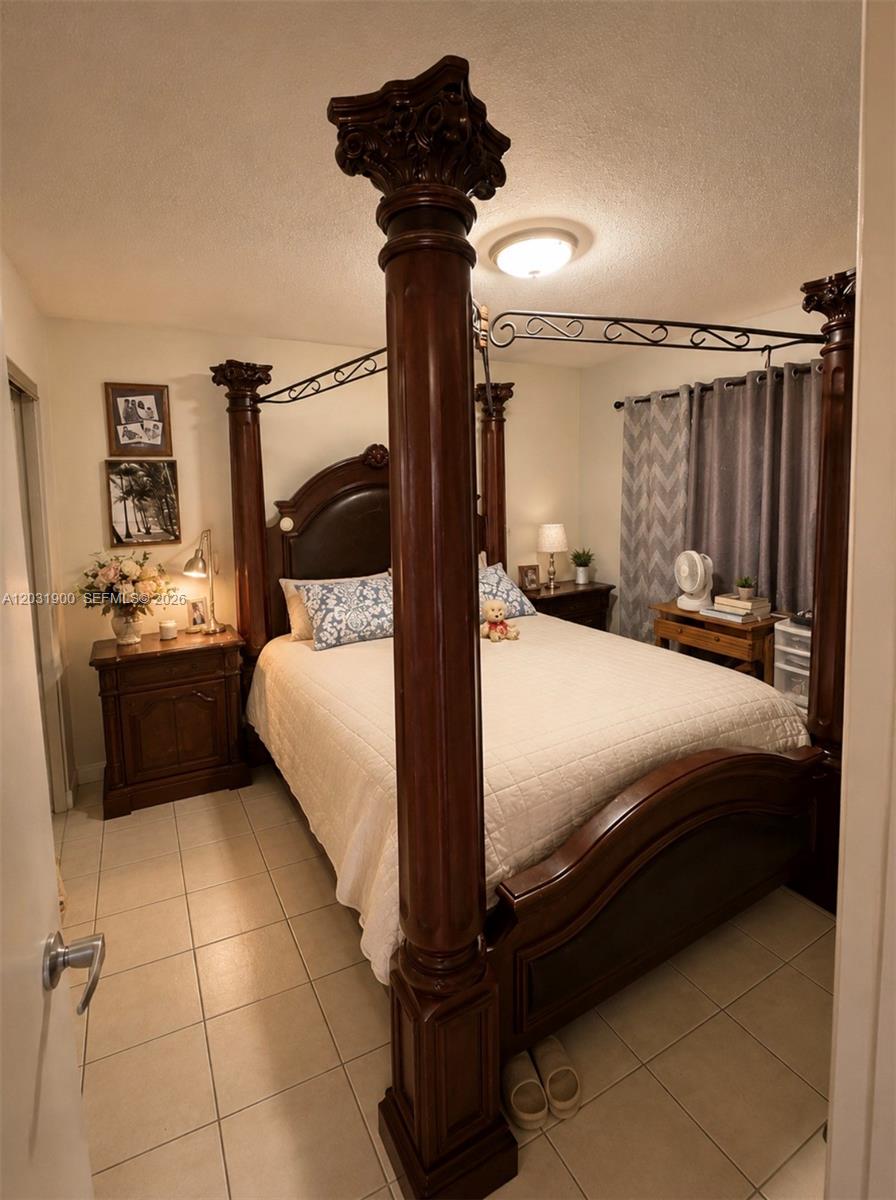 12860 Southwest 43rd Drive, Unit 146B Miami, FL 33175 - Photo 8 of 12 a bedroom with a bed and a mirror