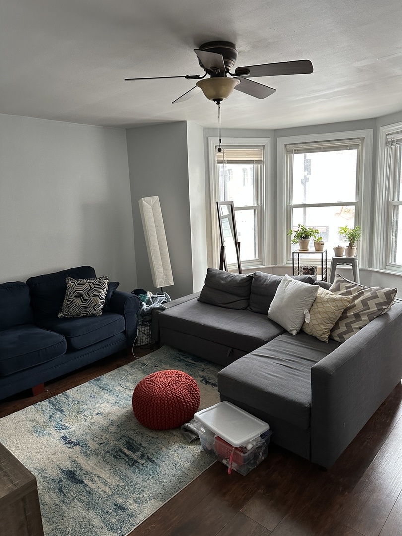 1127 North State Street, Unit 2A Chicago, IL 60611 - Photo 6 of 11 a living room with furniture a window and a chandelier