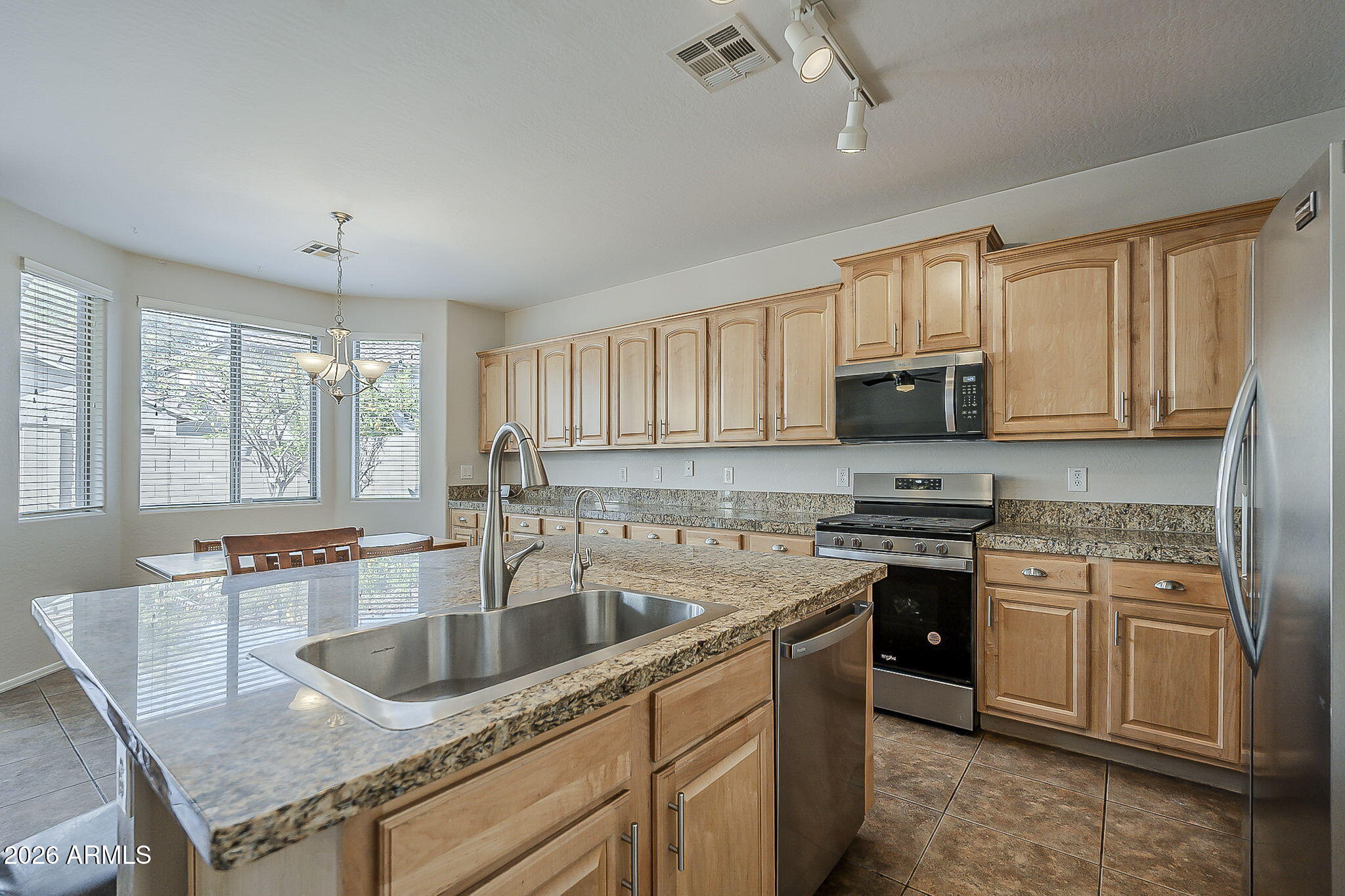 3816 East Phelps Street Gilbert, AZ 85295 - Photo 14 of 47 a kitchen with stainless steel appliances granite countertop a stove sink microwave and cabinets