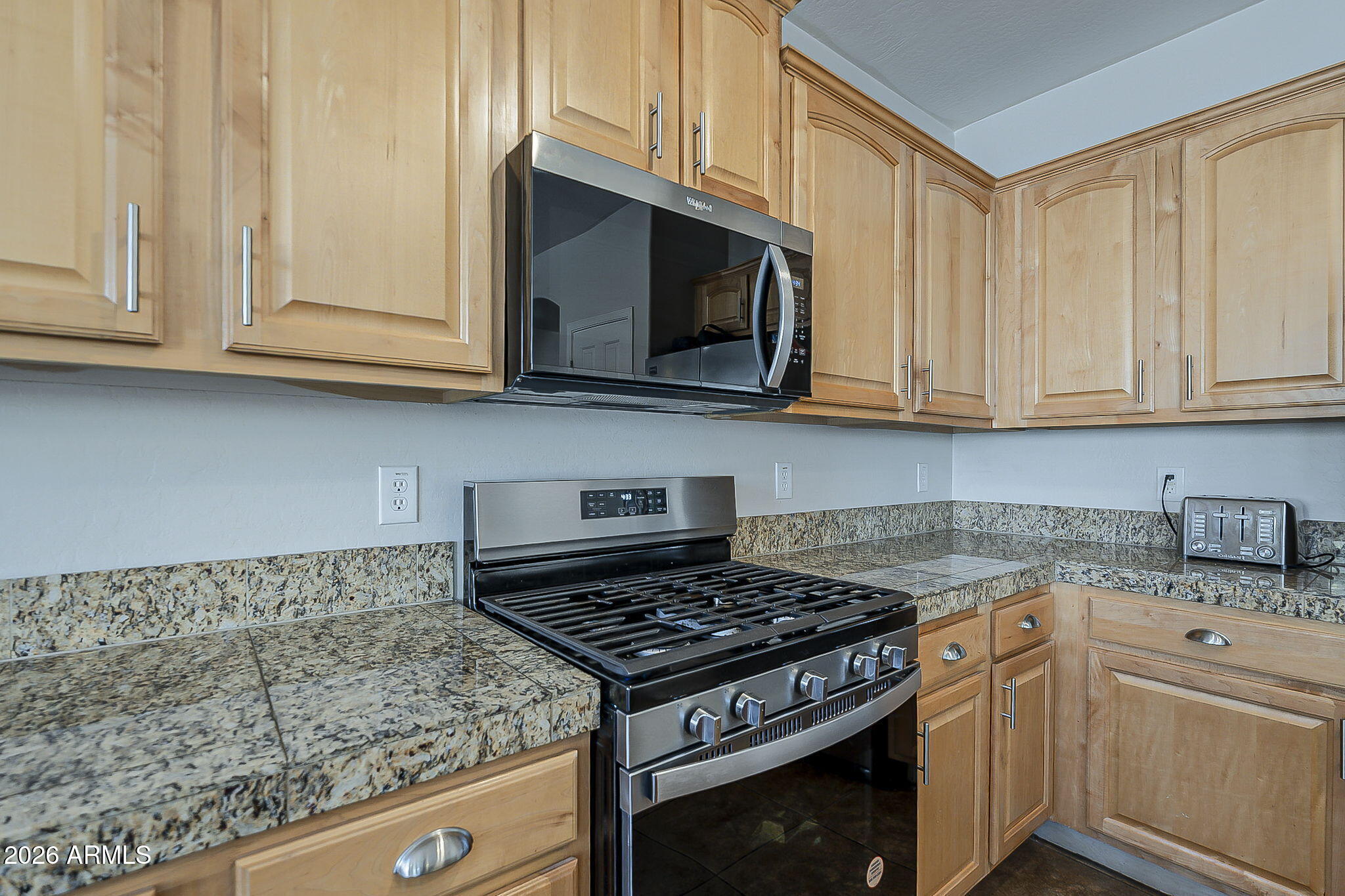 3816 East Phelps Street Gilbert, AZ 85295 - Photo 17 of 47 a kitchen with granite countertop white cabinets and a stove top oven