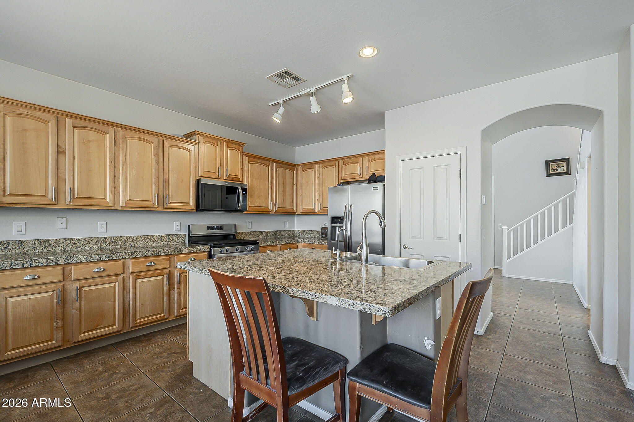 3816 East Phelps Street Gilbert, AZ 85295 - Photo 18 of 47 a kitchen with a dining table chairs and refrigerator