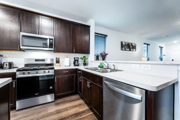 a kitchen with stainless steel appliances a stove microwave and sink
