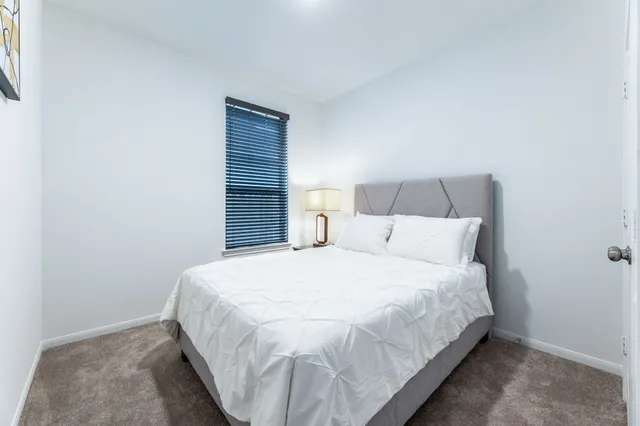 a bedroom with a bed and a mirror on dresser