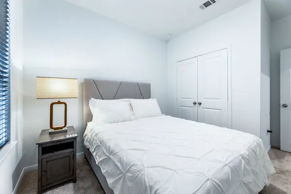 a bedroom with a bed and a mirror on dresser