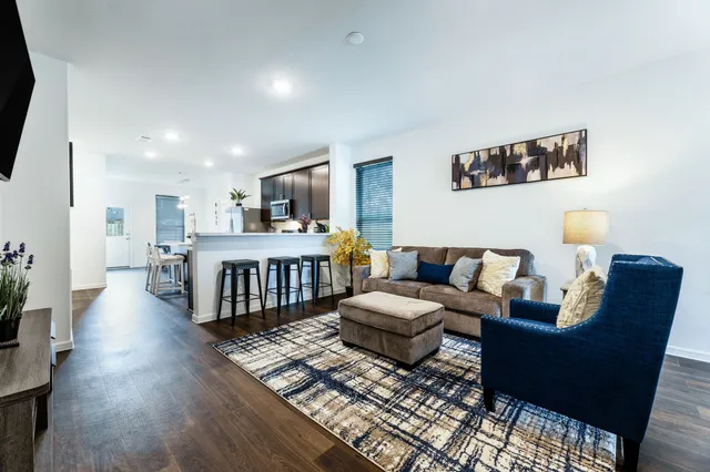 a living room with furniture and a wooden floor