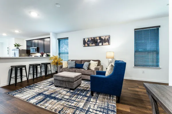 a living room with furniture and a wooden floor