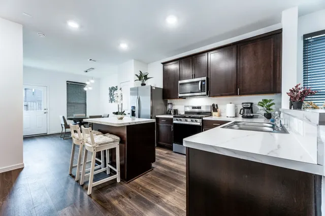a kitchen with stainless steel appliances a stove microwave and sink