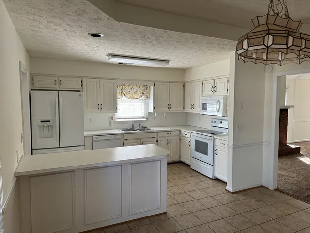 a kitchen with white cabinets and white appliances