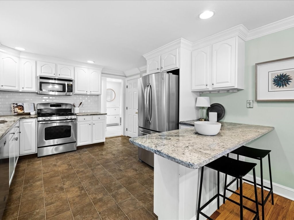 16 Lilly Lane Dedham, MA 02026 - Photo 8 of 27 a kitchen with stainless steel appliances granite countertop a stove refrigerator sink and cabinets