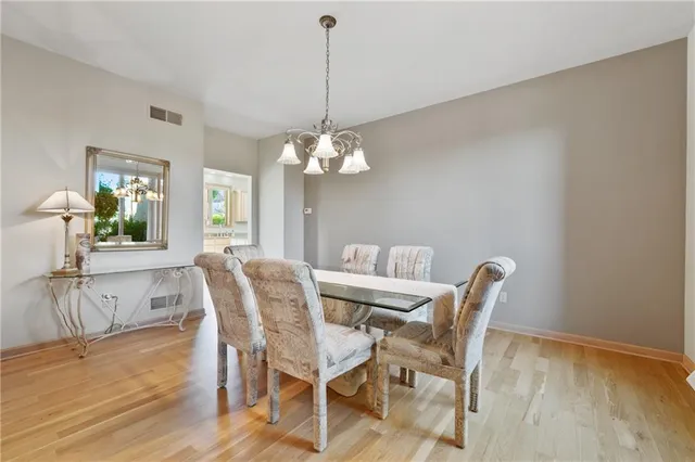a dining room with furniture a chandelier and wooden floor